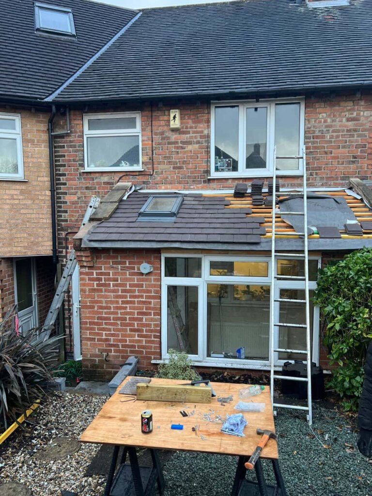 This is a photo of a roof extension that is having new roof tiles installed. This is a photo taken from the roof ridge looking down a tiled pitched roof on to a flat roof. Works carried out by Worksop Roofing Repairs