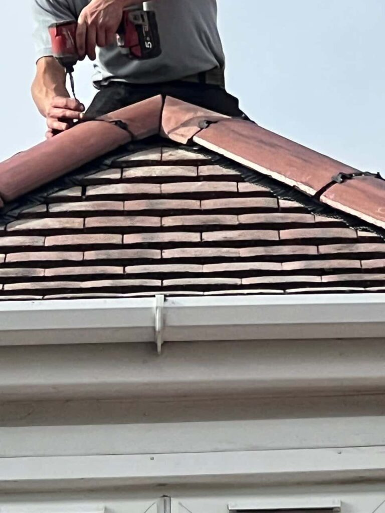 This is a photo of one of the operatives of Worksop Roofing Repairs installing new ridge tiles