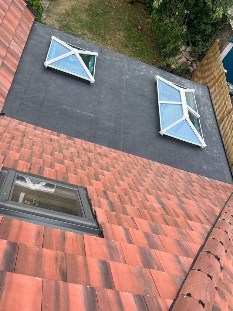 This is a photo taken from the roof ridge looking down a tiled pitched roof on to a flat roof. Works carried out by Worksop Roofing Repairs